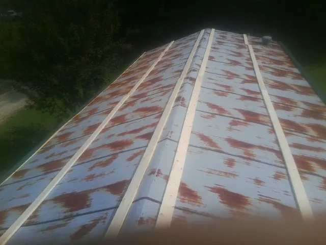 Rusted metal roof panels with new wood purlins before replacement — Storm Damage Roof Repair in Loma by Roofing Brothers