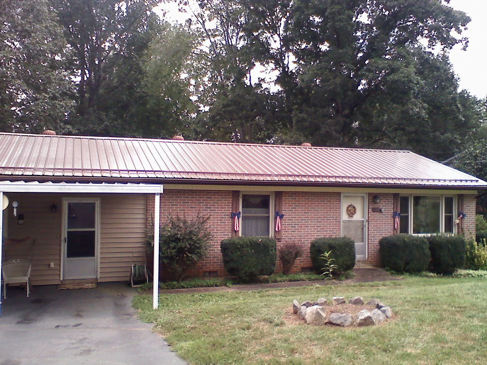 Bronze metal roof and carport on a brick ranch home — Roof Repair work by our crew in Loma