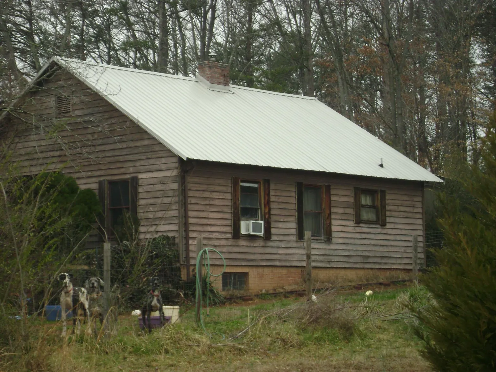 White metal roof on an old wood sided farmhouse, from a Metal Roof Installation job in Loma